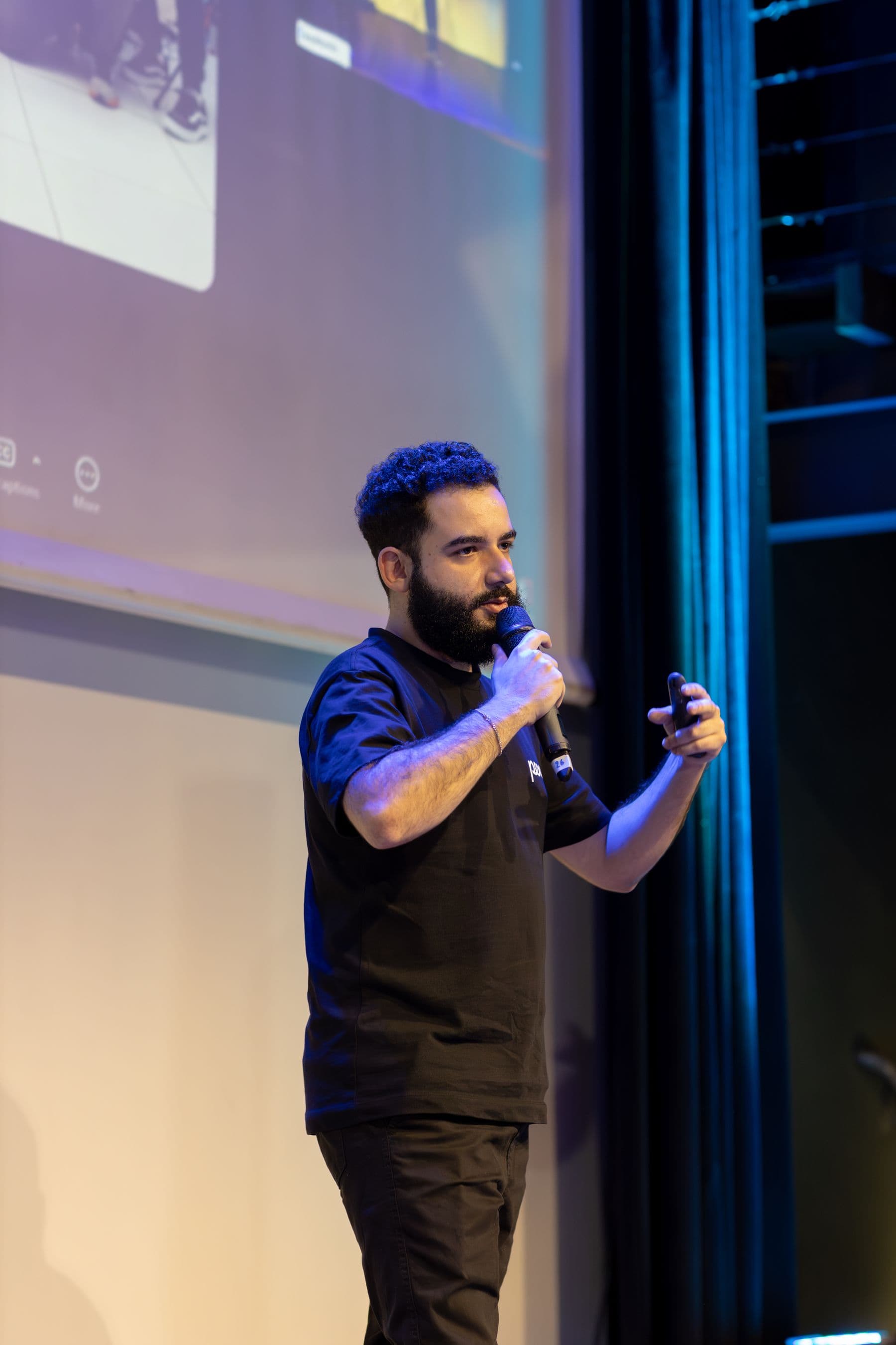 A speaker presenting on stage at a conference