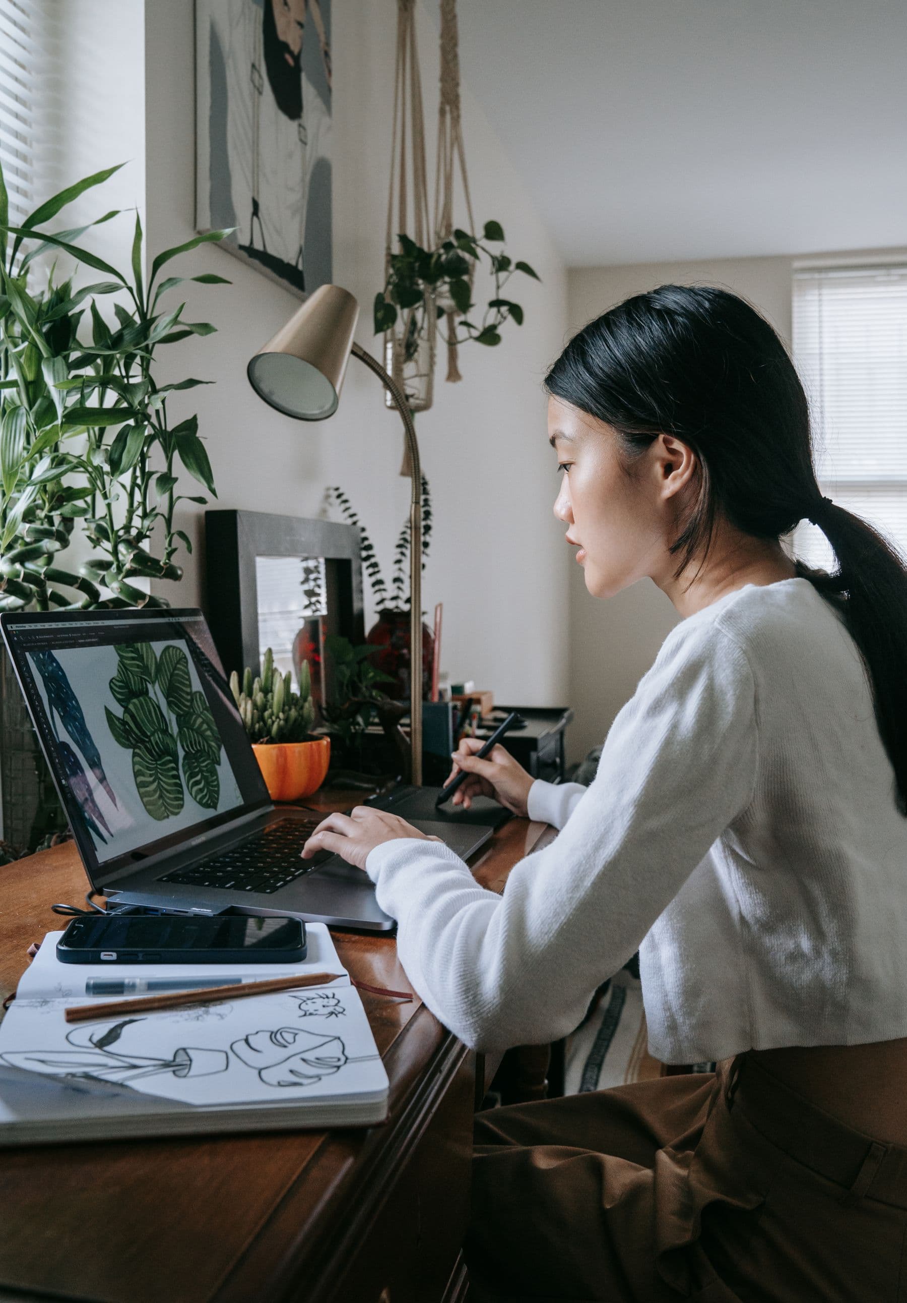 A coordinator working at a desk with plants