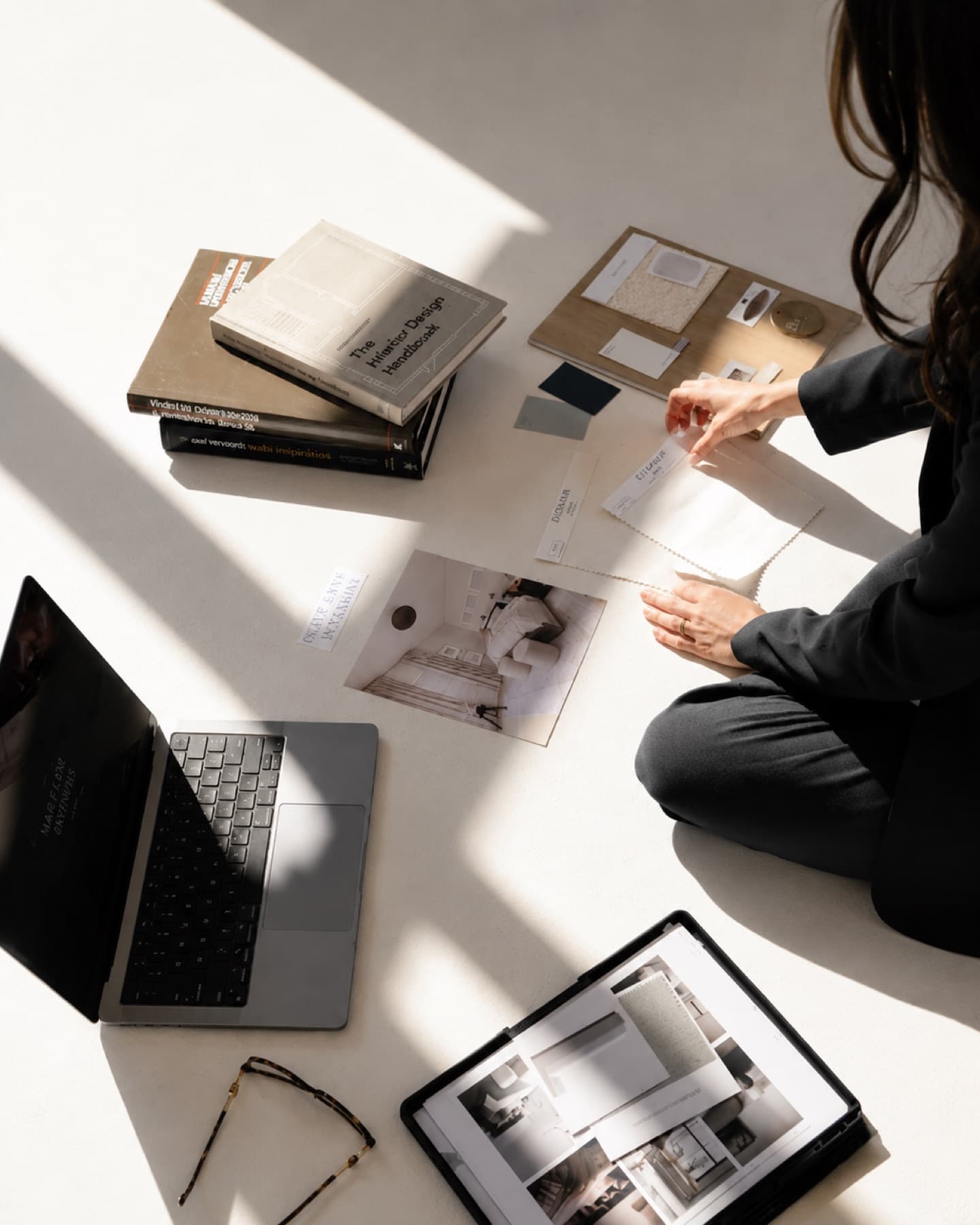 A planner at work among books, a laptop and moodboards